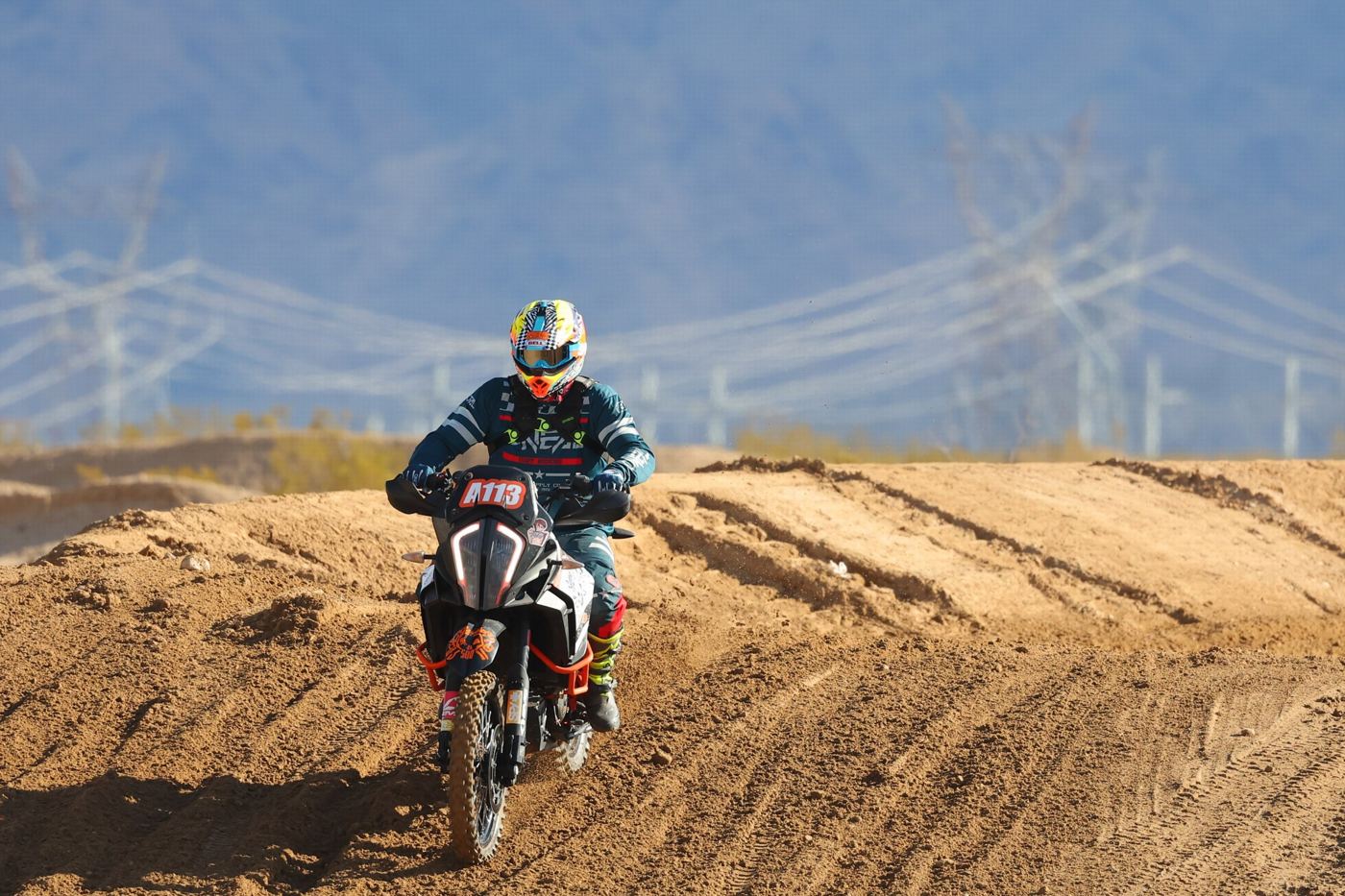 Coming over a berm with power lines behind