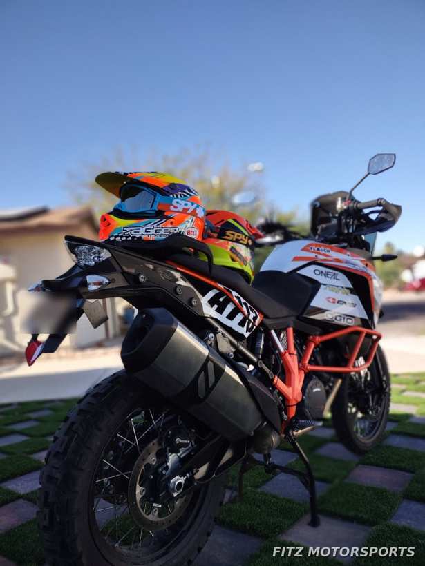 Rear view of the KTM with race helmets on the seat