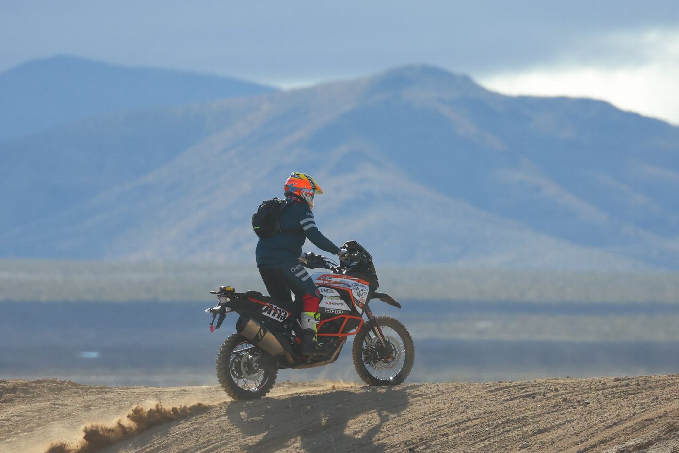 Cresting a ridge with the mountains behind